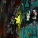 Dynamic street art featuring colorful graffiti and 3D masks on a textured wall.