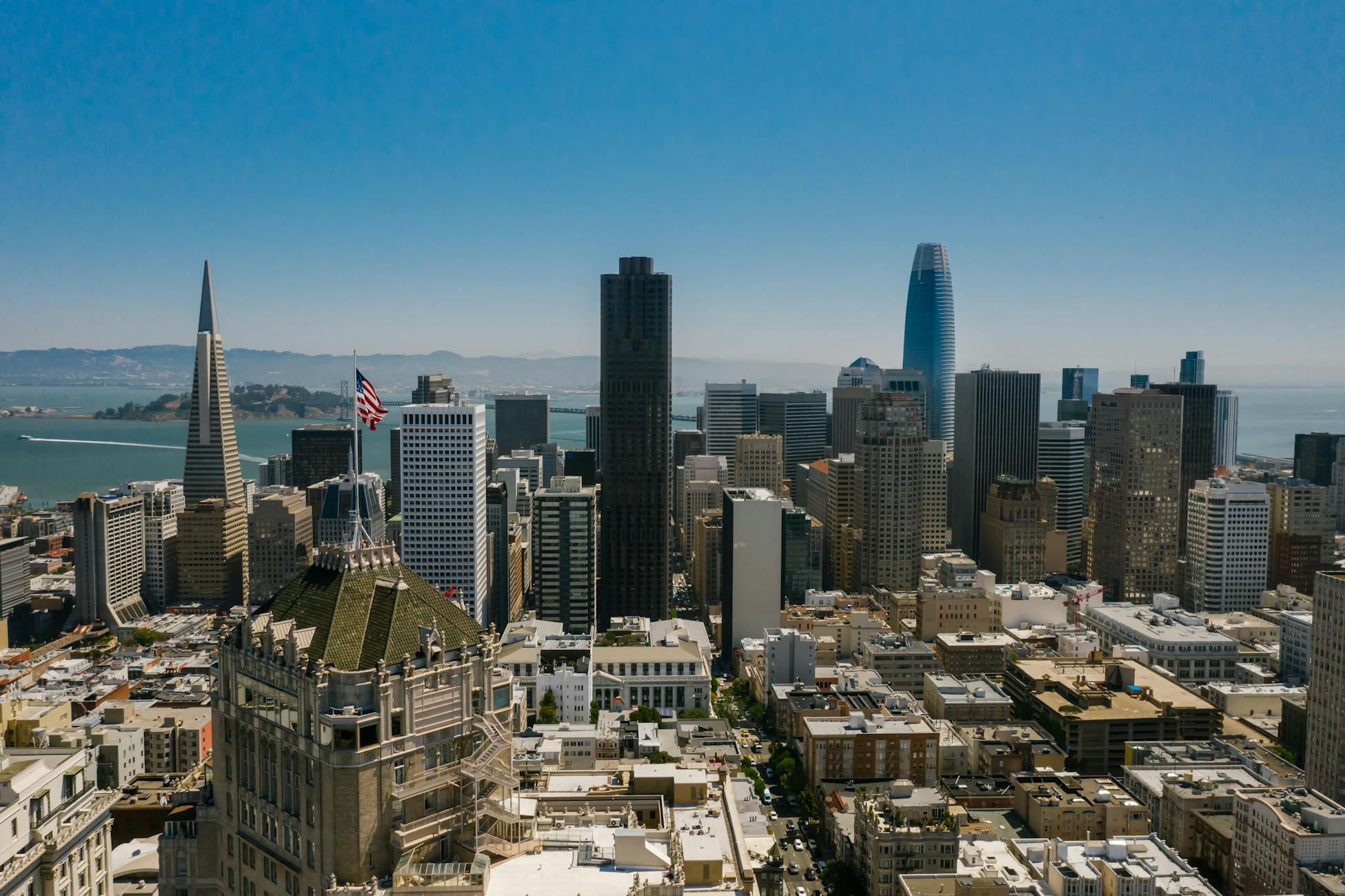 Aerial view of San Francisco skyline with iconic skyscrapers and ocean backdrop.