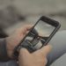 Close-up of hands holding a smartphone showing a mountain scene, captured outdoors in Banff.