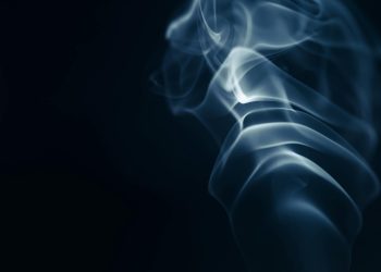 Abstract image of smoke curls set against a dark backdrop, creating an artistic effect.