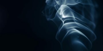Abstract image of smoke curls set against a dark backdrop, creating an artistic effect.