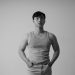 Stylish black and white portrait of an Asian man wearing a tank top in a studio setting.