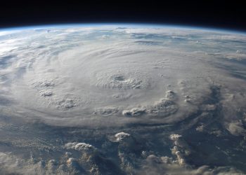 A stunning aerial view of Earth with a massive swirling hurricane, highlighting meteorological beauty.