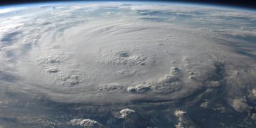 A stunning aerial view of Earth with a massive swirling hurricane, highlighting meteorological beauty.