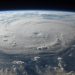 A stunning aerial view of Earth with a massive swirling hurricane, highlighting meteorological beauty.