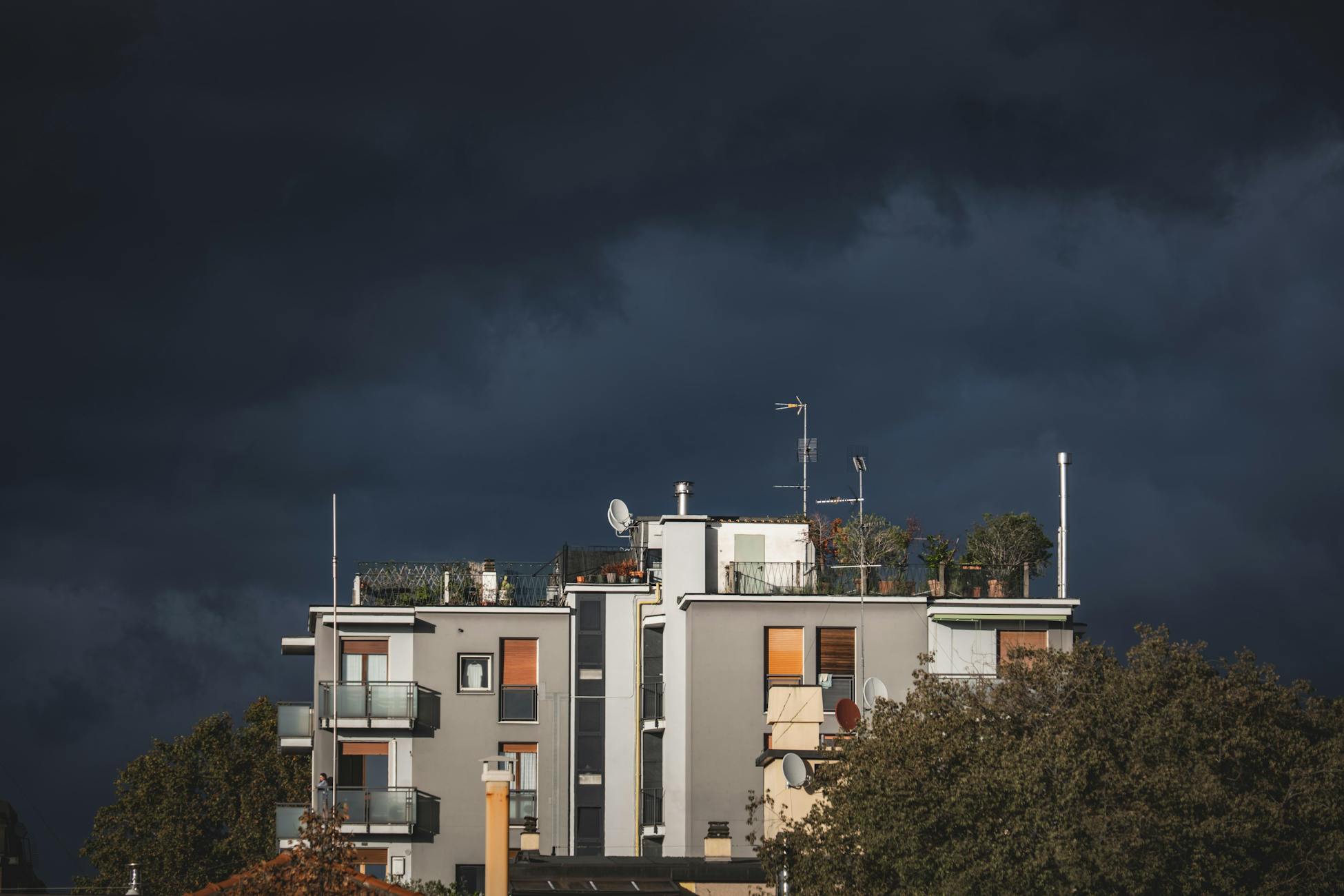 Urban residential building stands out against a dramatic stormy sky, creating a striking contrast.