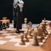 Close-up of a robotic arm playing chess against a human, showcasing AI technology in a classic board game setting.