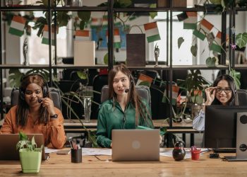 A multicultural group of women working in a modern office setting, showcasing teamwork.