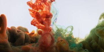 Colorful ink creating mesmerizing patterns in water, highlighting fluid motion and abstraction.