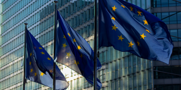 EU flags waving in front of the European Commission building in Brussels, Belgium.