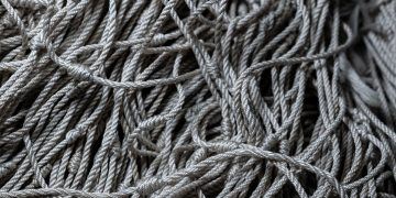 Detailed close-up of gray tangled ropes, perfect for textile and texture backgrounds.