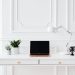 A minimalist home office setup featuring a laptop on a white desk with decor items.