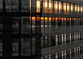 Urban building facade reflecting a beautiful sunset in the windows.
