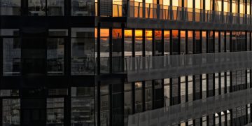Urban building facade reflecting a beautiful sunset in the windows.