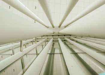 Upward view of modern interior columns in a geometrically structured space.