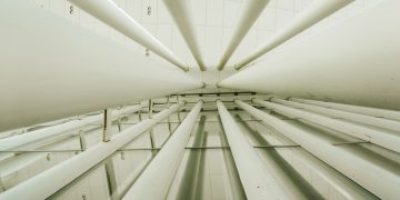 Upward view of modern interior columns in a geometrically structured space.