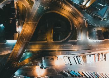 Top-down view of a city intersection with traffic and infrastructure at night.