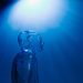 Transparent robotic figure illuminated by blue light, symbolizing AI and futuristic technology.