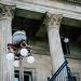 An elegant view of classic architectural columns with an antique street lamp, ideal for urban landscapes.