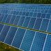 High angle pole mounted solar energy trackers installed on green field in solar power station