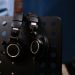 Close-up of professional headphones hanging on a perforated music stand in a studio setting.