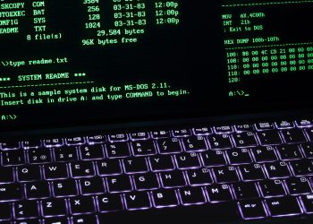 A classic MS-DOS terminal screen displayed on a laptop keyboard with vivid illumination.