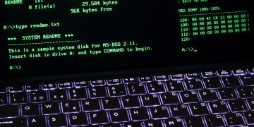A classic MS-DOS terminal screen displayed on a laptop keyboard with vivid illumination.