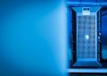 Close-up of a modern server unit in a blue-lit data center environment.