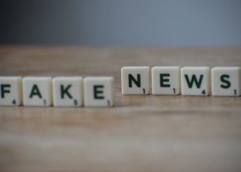 Scrabble tiles spelling 'Fake News' on a wooden surface highlighting misinformation.