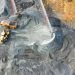 A top-down view showcasing mining operations with excavators and conveyor belts.
