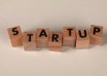 Wooden blocks forming the word 'STARTUP' on a neutral background, symbolizing new business ventures.