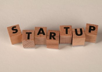 Wooden blocks forming the word 'STARTUP' on a neutral background, symbolizing new business ventures.