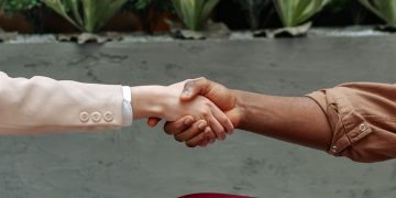 Close-up of diverse hands shaking indoors, symbolizing partnership and agreement.