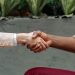 Close-up of diverse hands shaking indoors, symbolizing partnership and agreement.