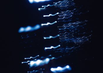 Dynamic abstract photograph of blue light patterns with a dark backdrop, creating a sense of motion and mystery.