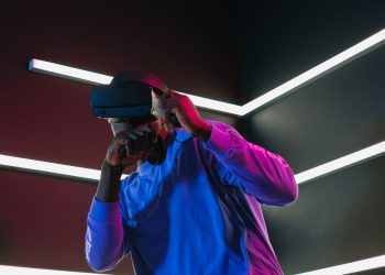An adult man fully engaged in a virtual reality simulation with VR headset in a futuristic setting.