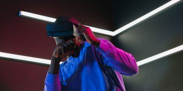 An adult man fully engaged in a virtual reality simulation with VR headset in a futuristic setting.