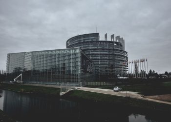 Modern architecture of the European Parliament in Strasbourg on a cloudy day.