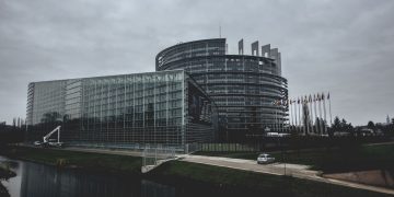 Modern architecture of the European Parliament in Strasbourg on a cloudy day.