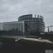 Modern architecture of the European Parliament in Strasbourg on a cloudy day.