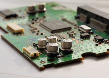 Detailed view of a green circuit board featuring capacitors and microchips.