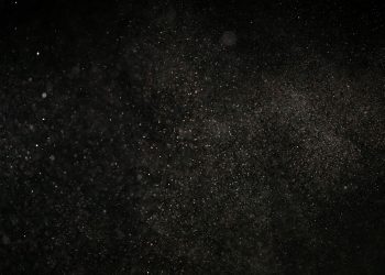 Dark textured background with floating particles, perfect for abstract designs.
