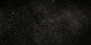 Dark textured background with floating particles, perfect for abstract designs.