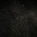 Dark textured background with floating particles, perfect for abstract designs.