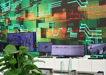 Digital screens display data on a circuit board background