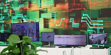 Digital screens display data on a circuit board background