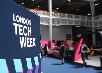 Vibrant indoor scene at London Tech Week with attendees and colorful displays.