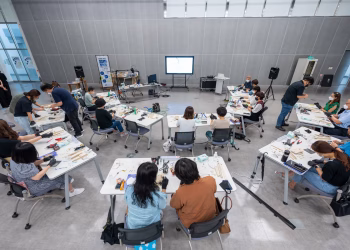 Overhead view of a hands-on classroom workshop with diverse students using hi-tech equipment.
