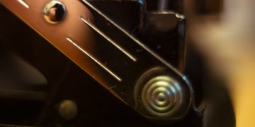 Close up of a metallic spring mechanism on black machinery.