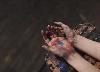 Close-up of hands covered in colorful paint, showcasing artistic creativity and expression.